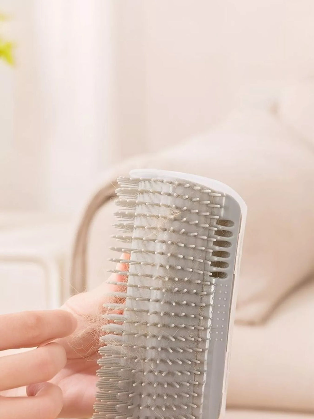 Brosse auto-toilettage pour chat après utilisation montrant les poils morts capturés dans les picots en silicone bleu, démonstration de l'efficacité du produit pour éliminer la mue et réduire les poils qui traînent dans la maison, facile à nettoyer en retirant simplement les poils accumulés
