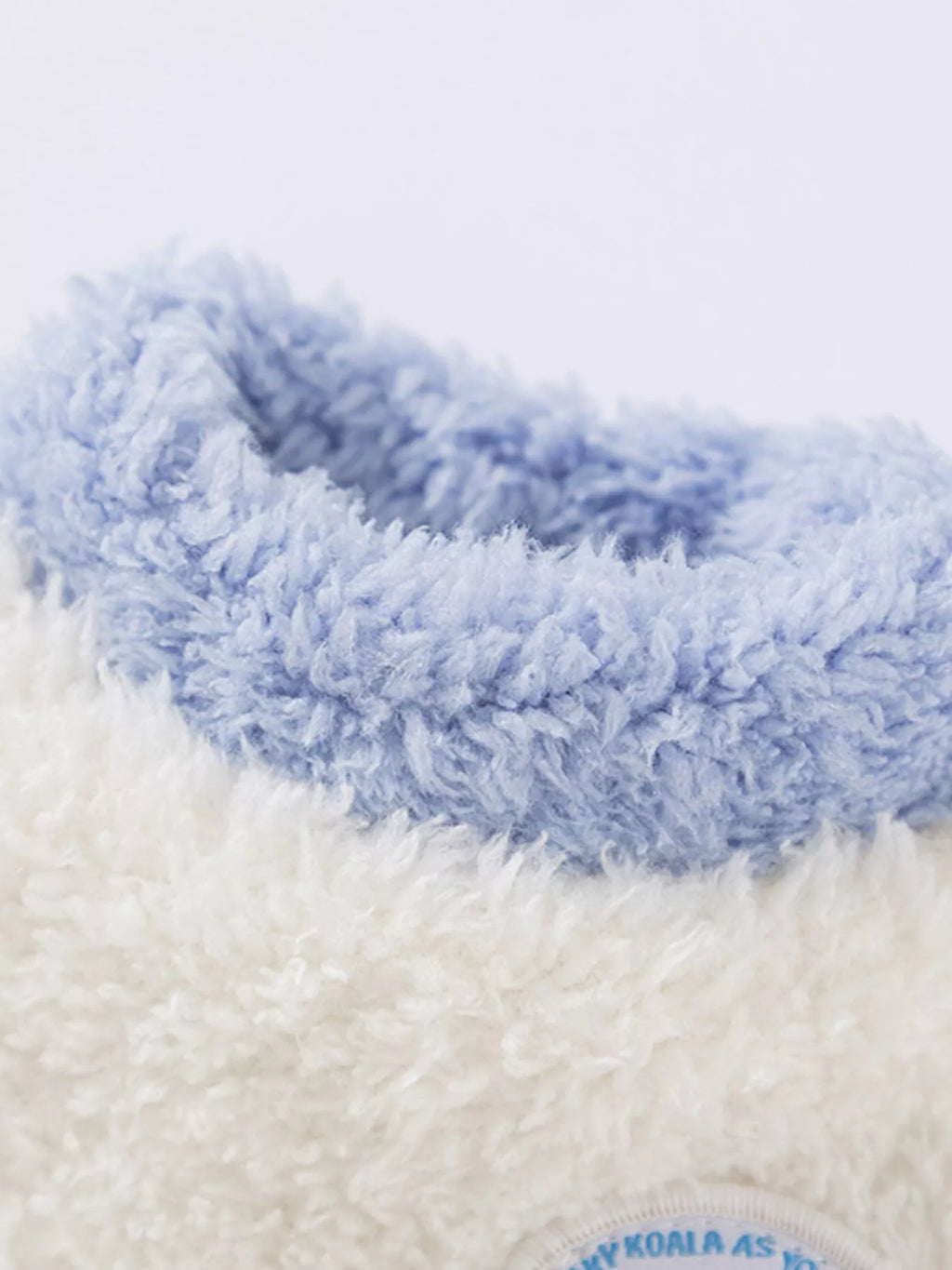 "Gros plan sur le tissu en peluche ultra-doux du pull pour animal - Détail de la texture moelleuse et du patch mignon - Zoom sur la qualité"